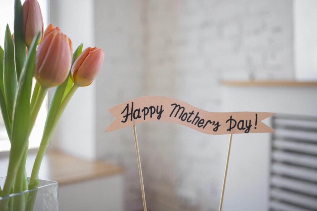 Pink tulips in a vase with a 'Happy Mother's Day!' banner sign