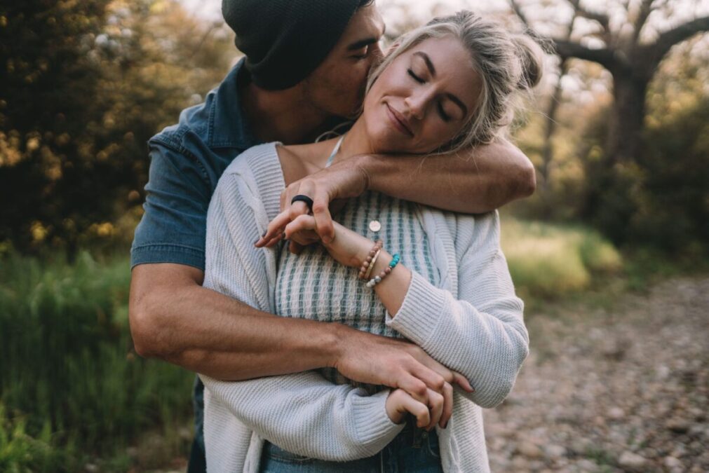 A young, authentic couple embracing peacefully outdoors, demonstrating healthy connection and modern dating strategies.